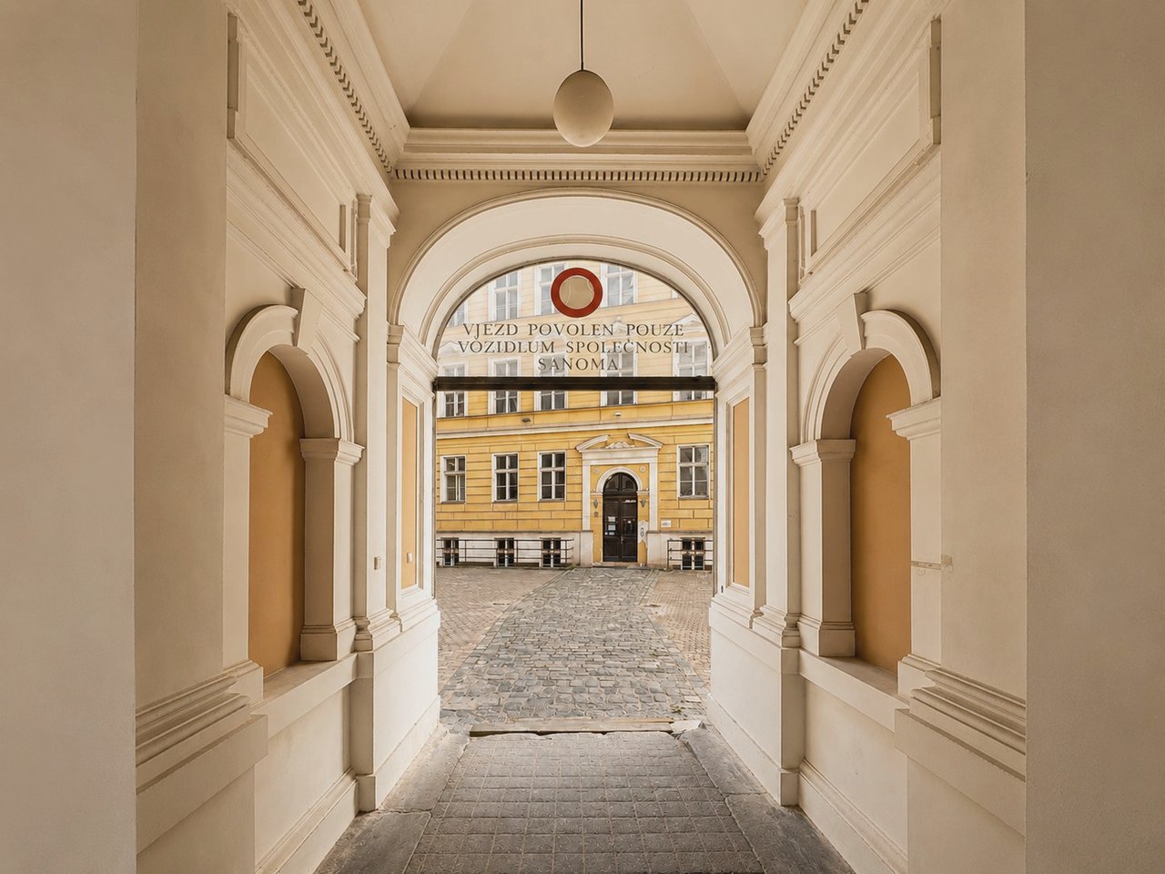 Klenutý priechod na nádvorie historickej budovy RyeBase